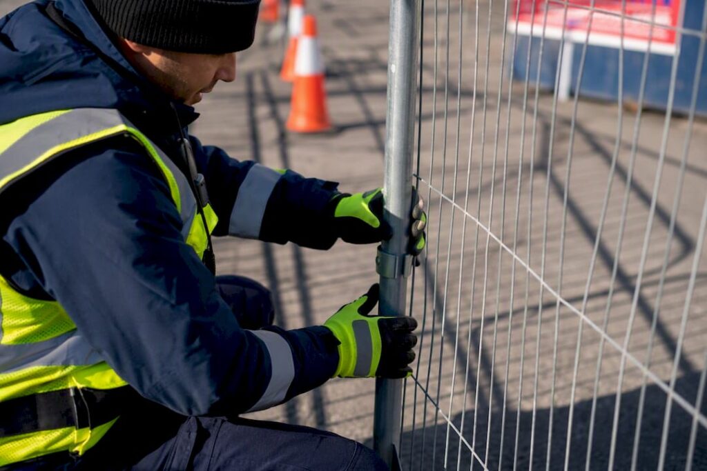 Security technician setting up event perimeter barrier