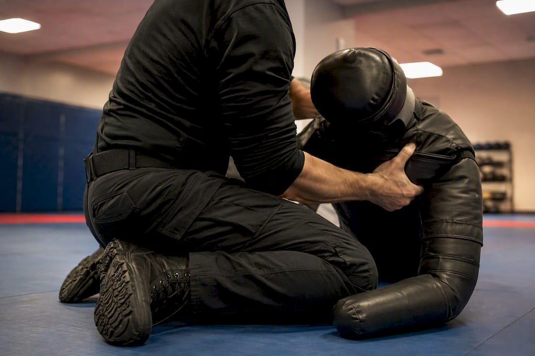 Trainee practicing defense techniques on dummy