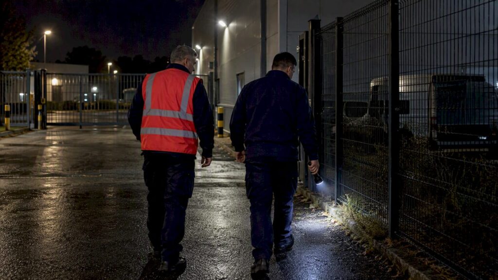 Facility managers inspect perimeter lighting at night